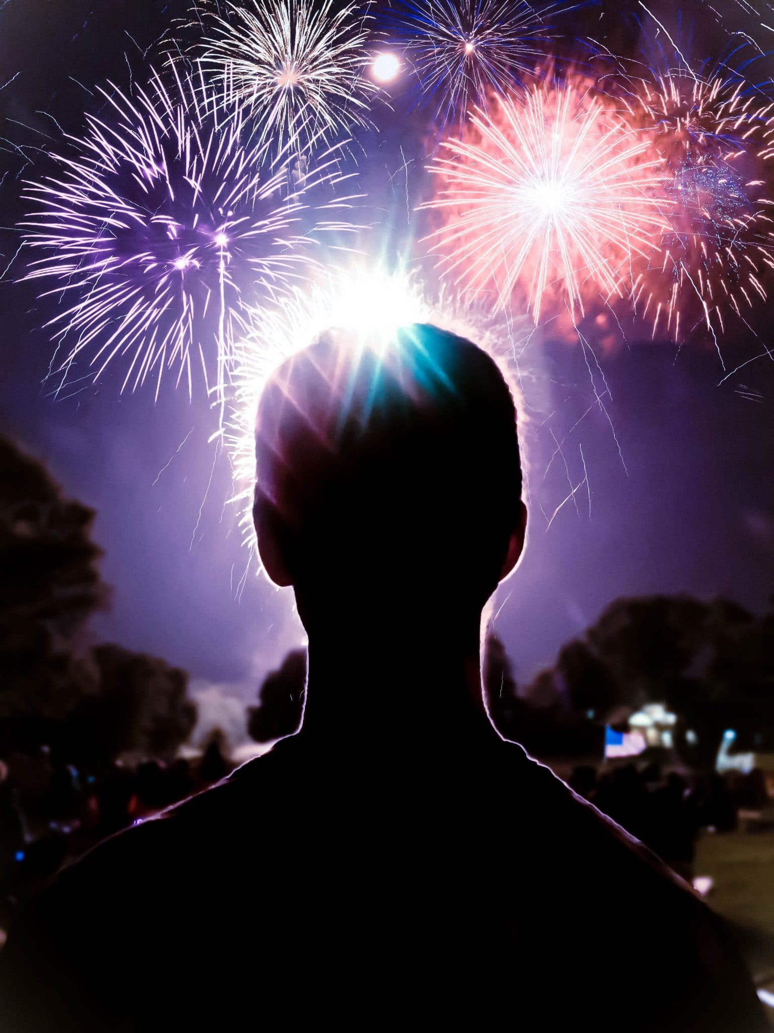 a man looking out at fireworks