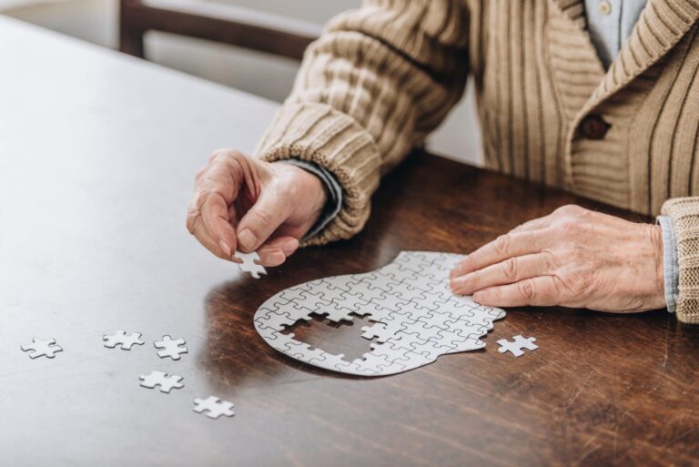 Hearing and Vision Loss Linked to Increased Risk of Dementia cropped view of senior man playing with puzzles