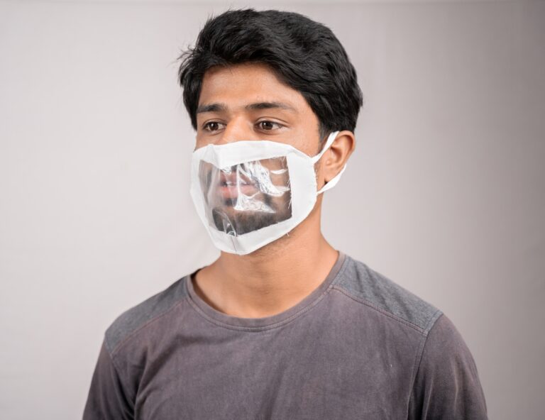 Creative Ways to Communicate While Wearing Masks young man with transparent Medical face mask, to help hearing impermeant or deaf people to understand lipreading during coronavirus or covid-19 outbreak.