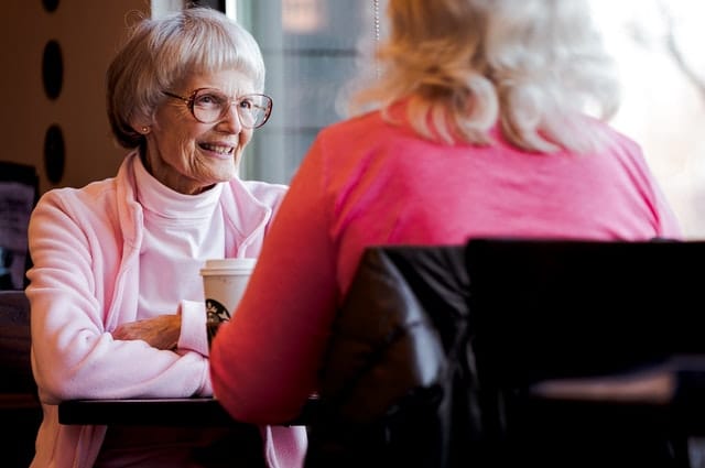 Elderly woman and another woman sitting at a table