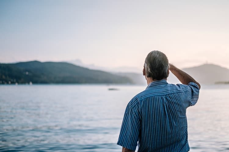 Man looks out on to lake.