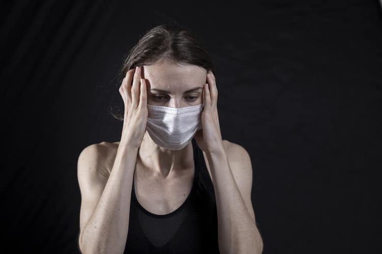 Woman wearing a mask in distress