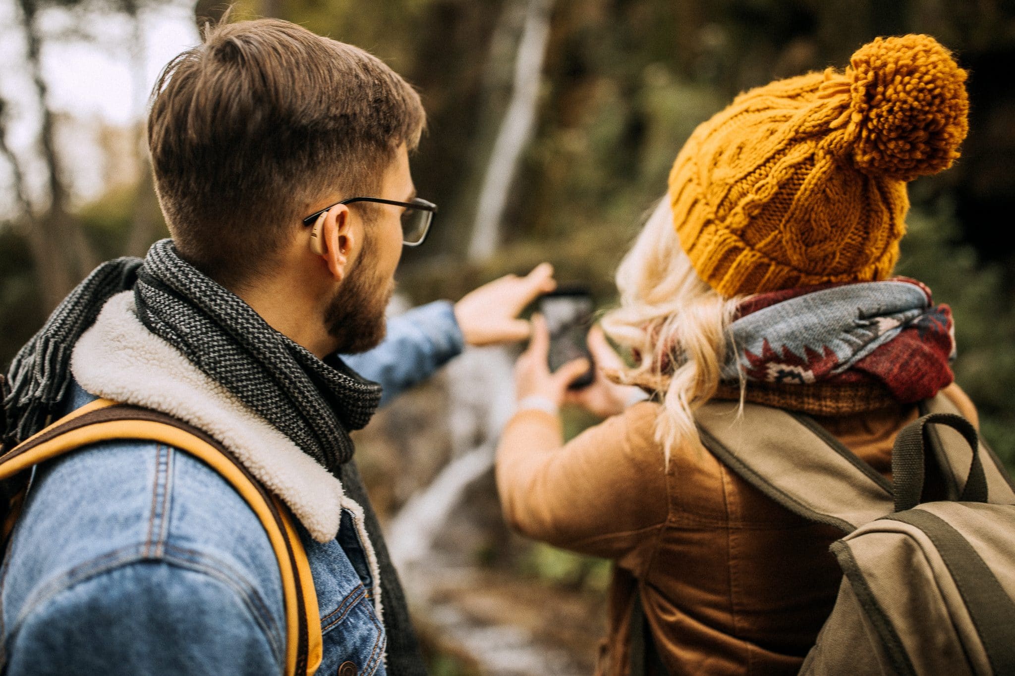 Young couple enjoying a hike together. Man is wearing hearing aids.