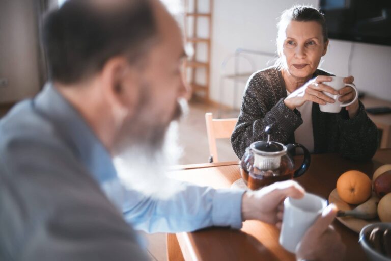 Man and woman having coffee at breakfast table.