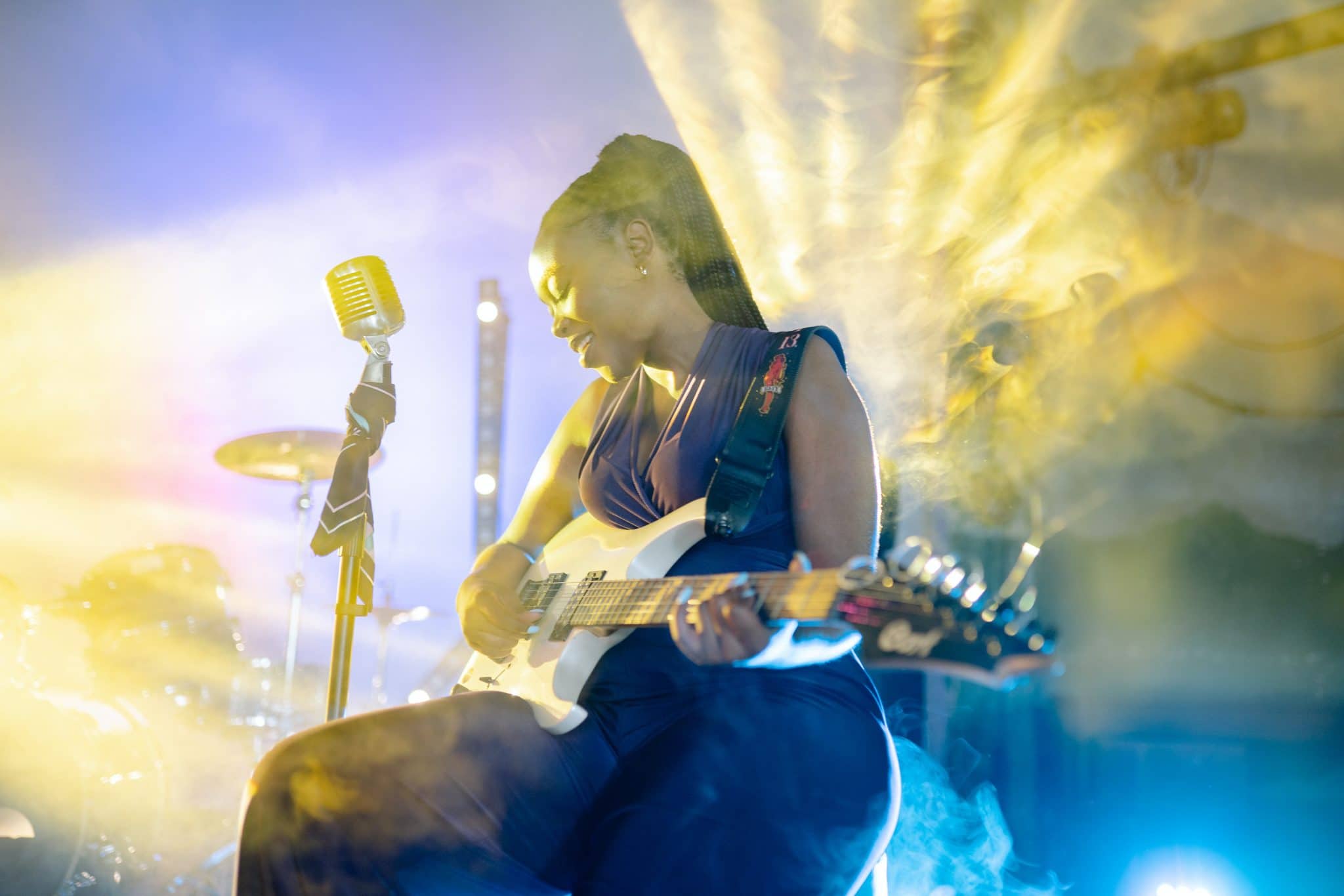Woman playing guitar onstage.