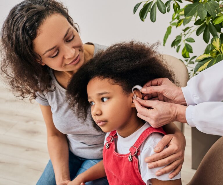 Little girl with her mother during a hearing aid fitting.