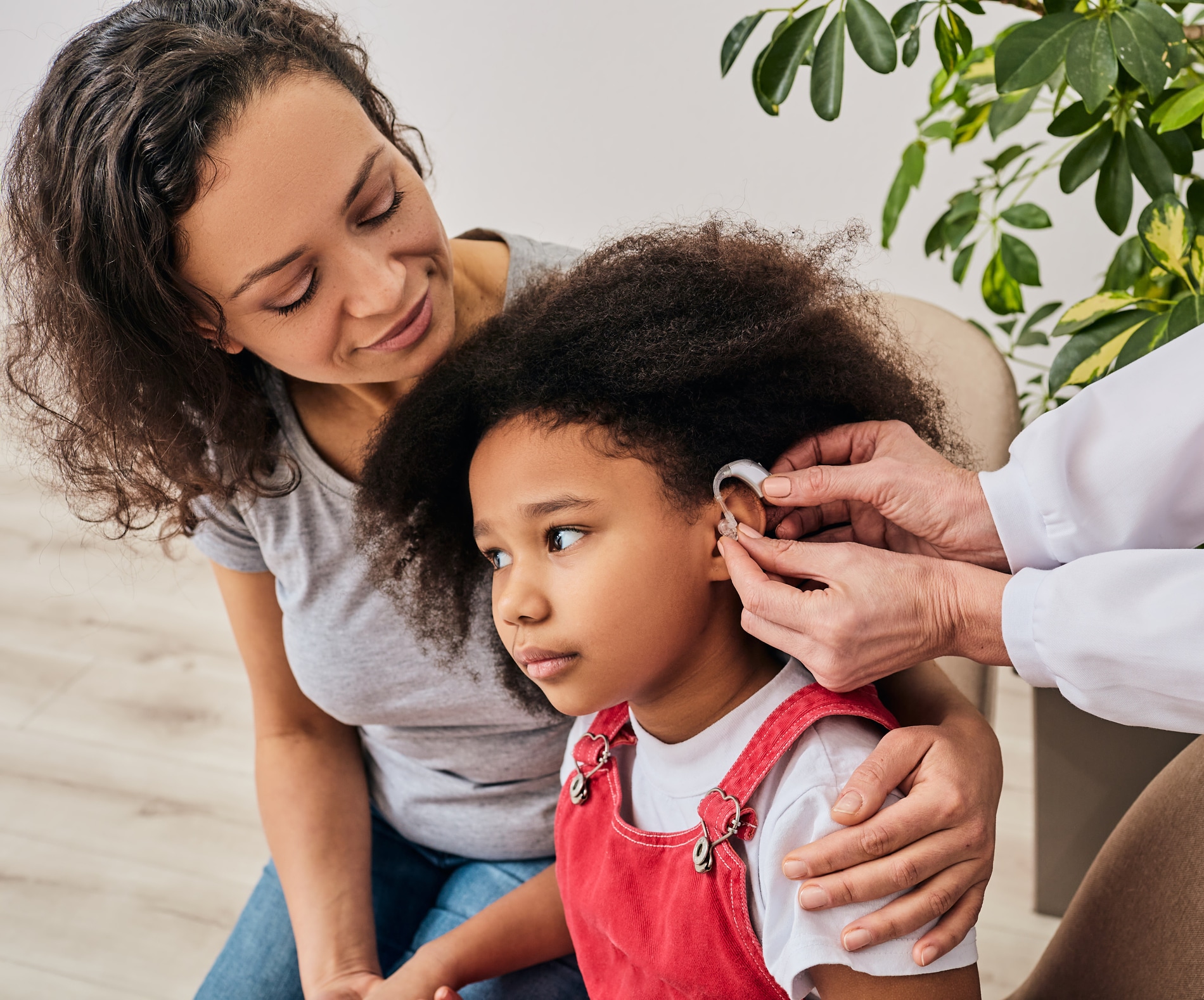 Little girl with her mother during a hearing aid fitting.