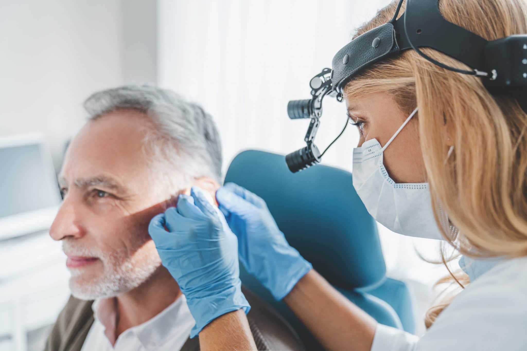 Man having his ears examined by a medical professional.