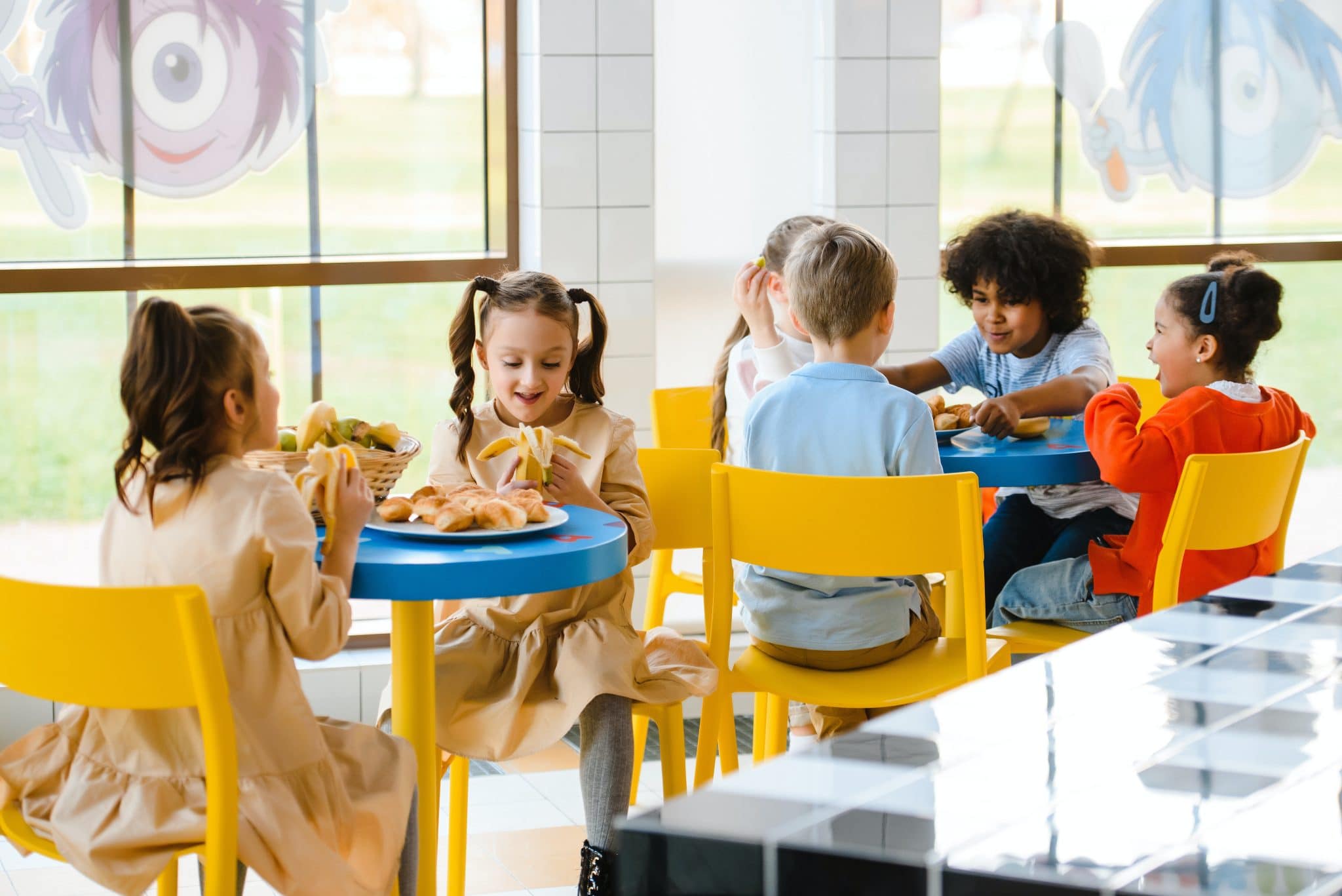 A group of school children eating lunch together.