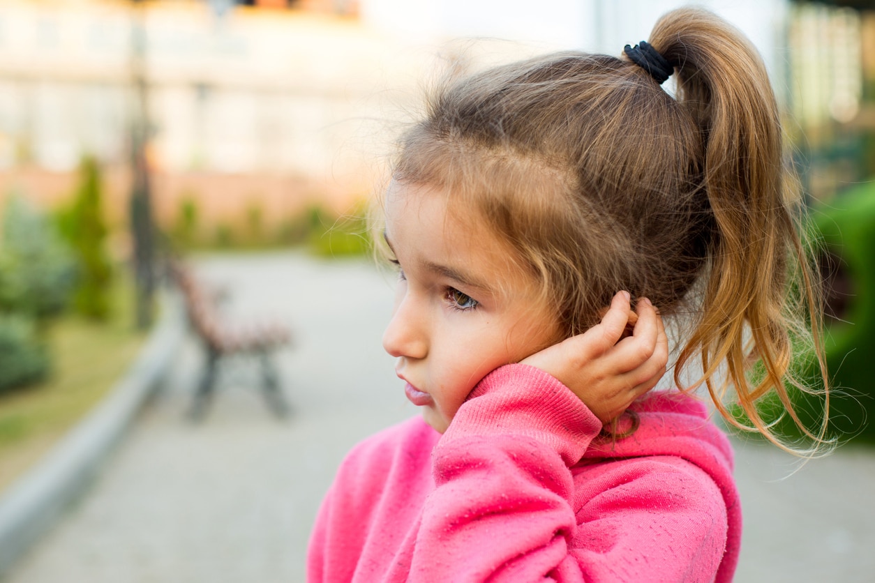 Young girl holding her ear