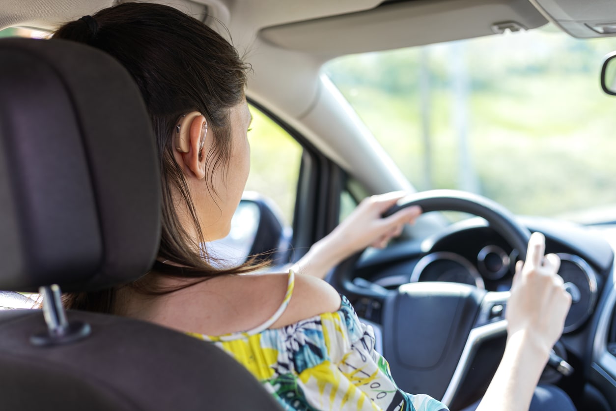 Woman wears hearing aids while driving