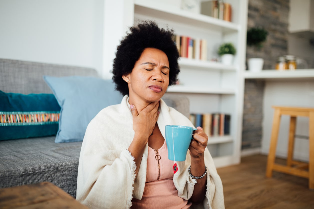 Woman with a sore throat drinking tea