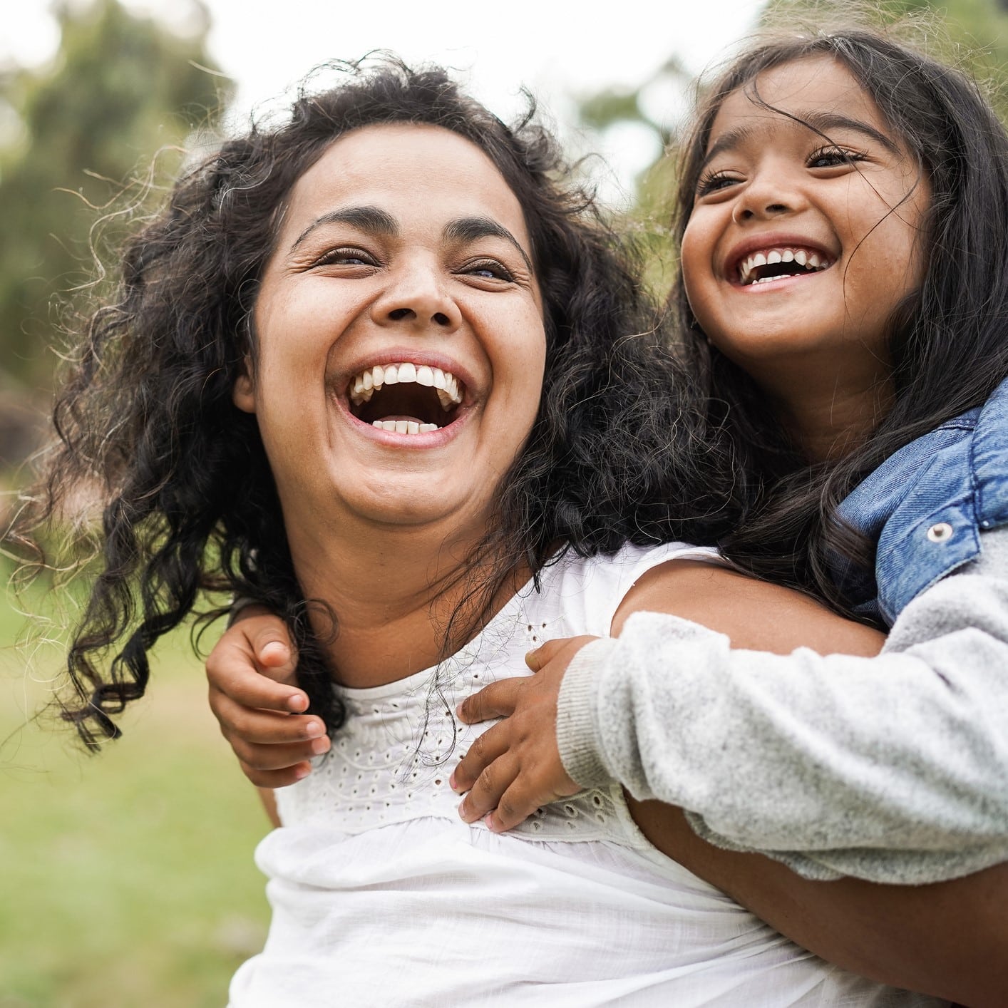 Happy parent and child playing in a park.