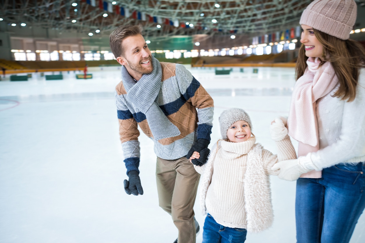 Happy family ice skating together.