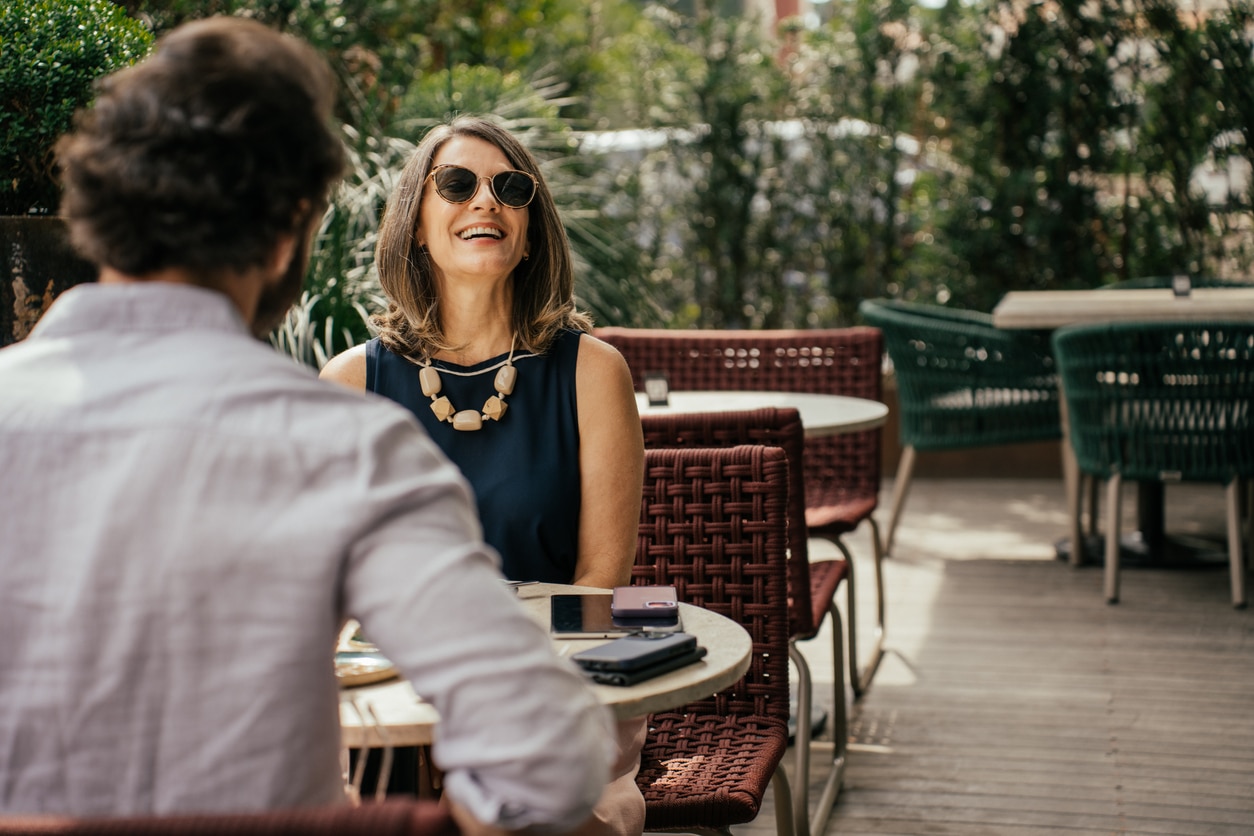 Couple eating lunch on the patio of a restaurant, feeling happy and comfortable after beginning allergy treatment